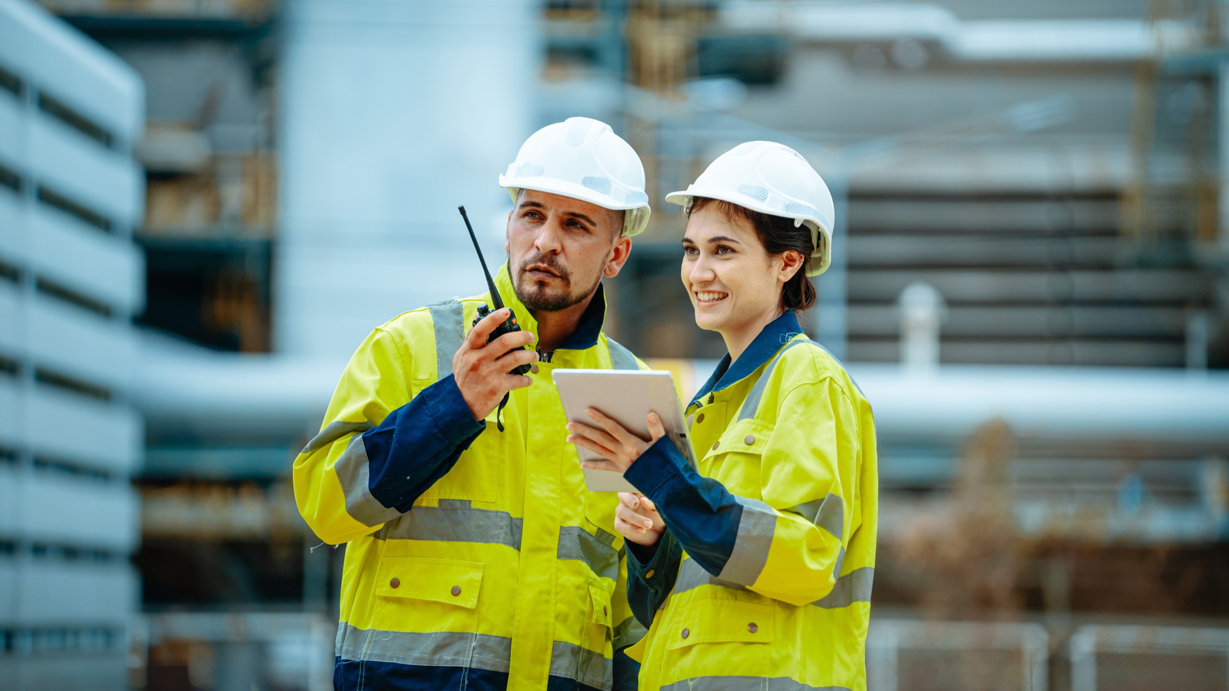 Two DP World colleagues in hi-vis reviewing operations on a tablet